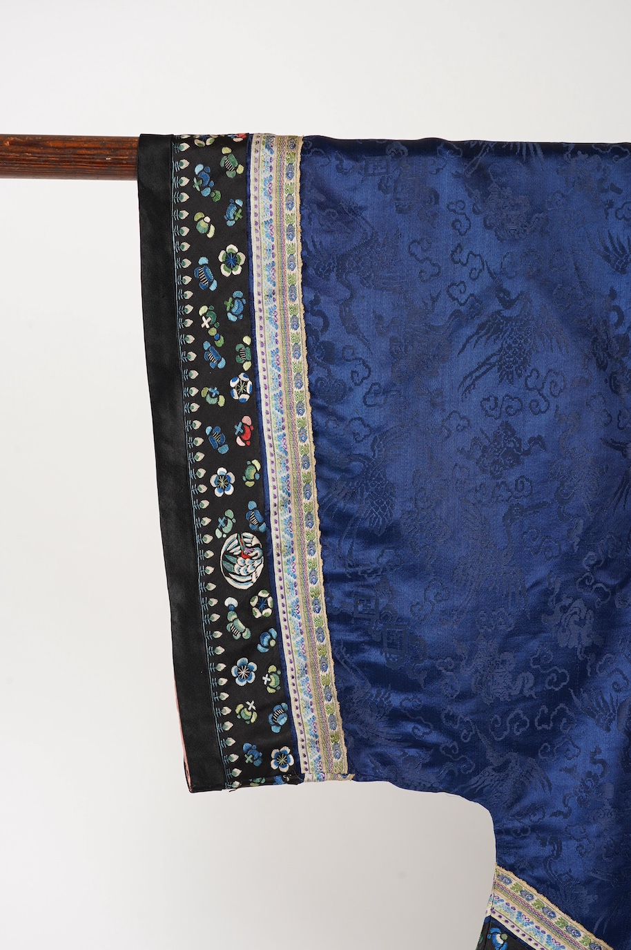 A late 19th century Chinese blue silk damask jacket, woven with Phoenix and auspicious symbols. The jacket edged with ornate rows of braiding and silk embroidery, the interior with original pink silk lining. The jacket f